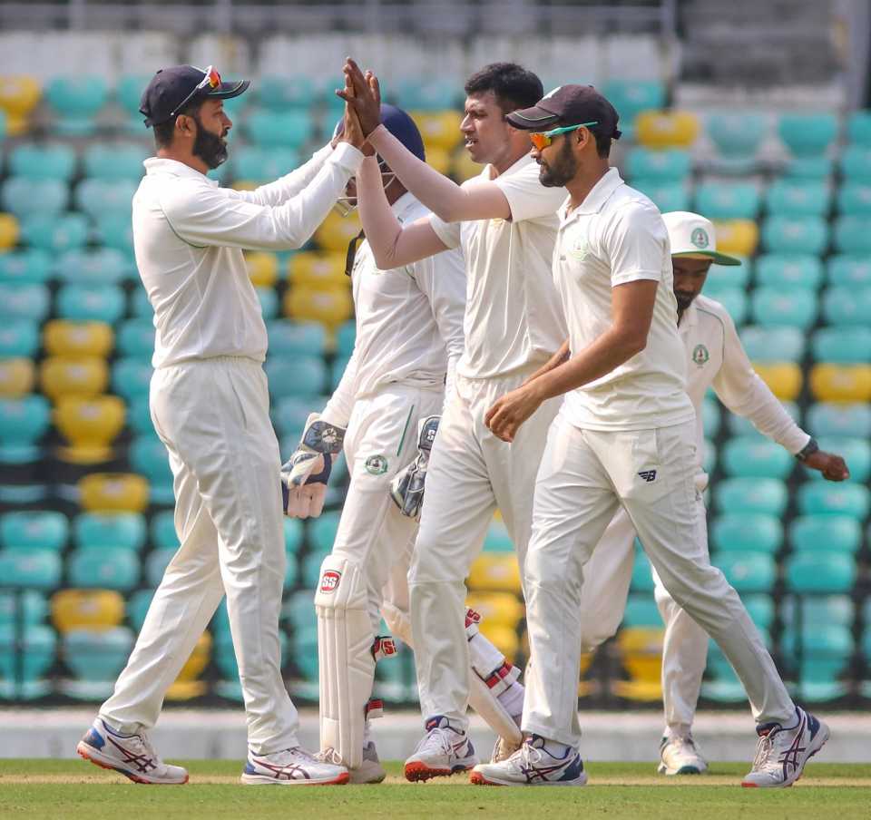 Akshay Wakhare celebrates a wicket with Wasim Jaffer while Aditya Sarwate looks on