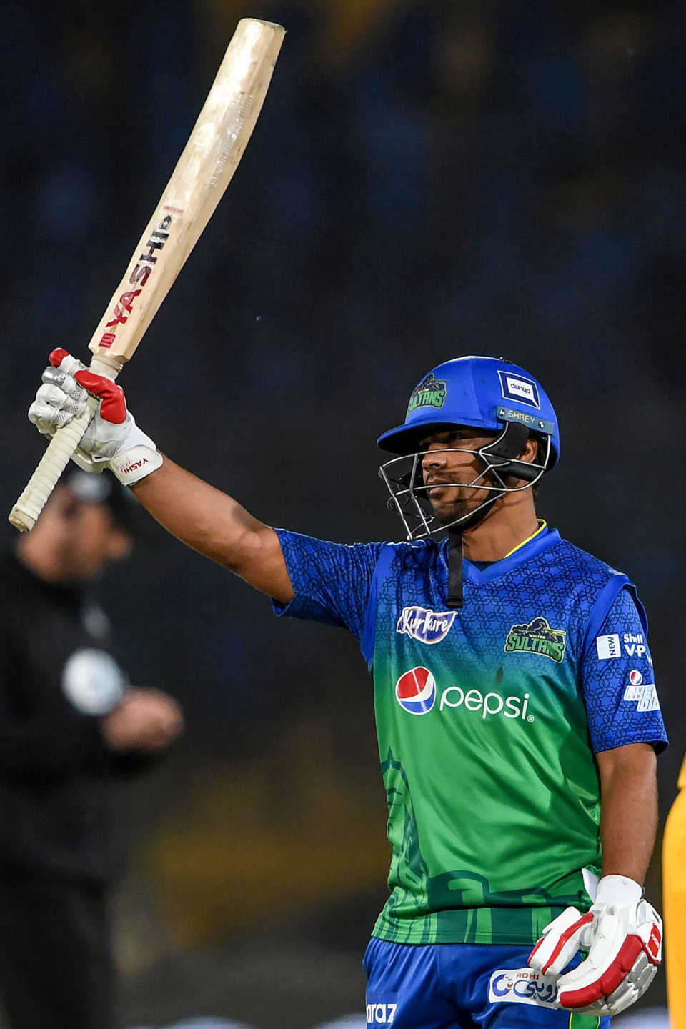 Zeeshan Ashraf raises his bat after reaching fifty