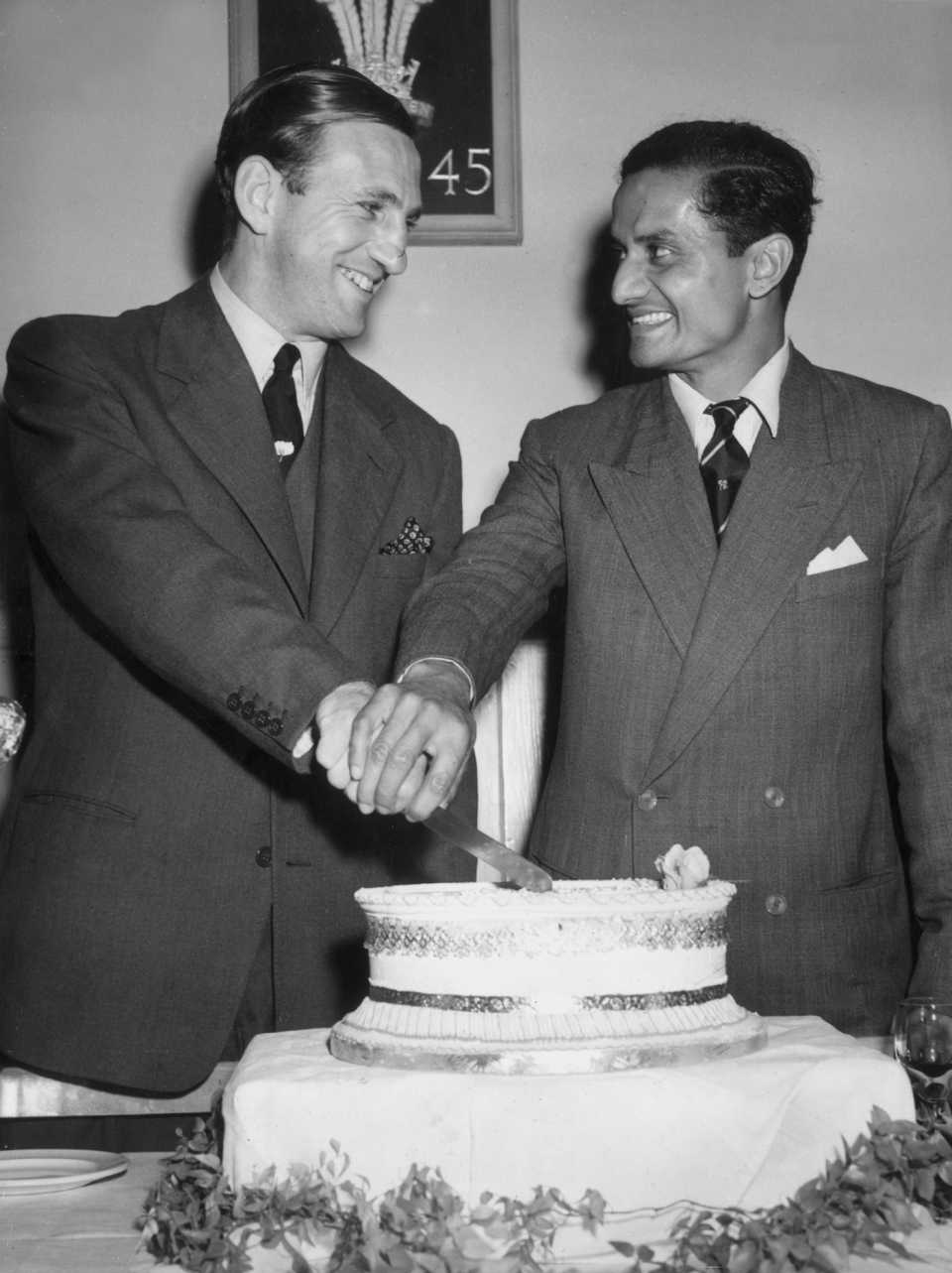Len Hutton and Vijay Hazare cut a cake during a party at the Oval