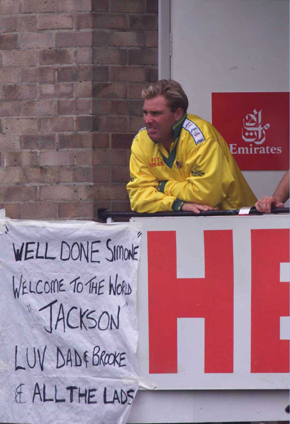 Shane Warne by a banner for his wife on the birth of their second child
