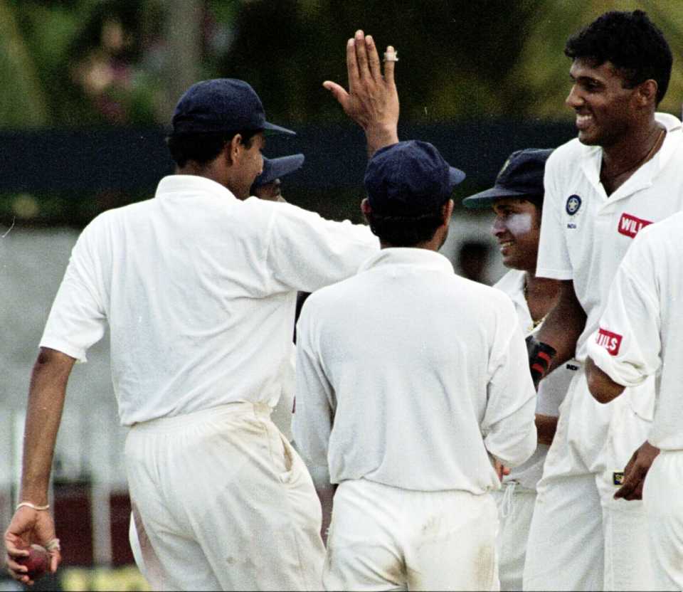 Abey Kuruvilla is congratulated by his team-mates after taking a wicket