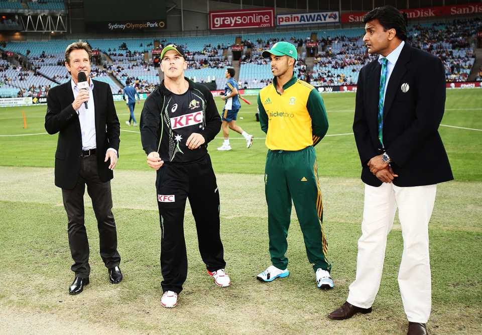 Aaron Finch tosses the coin, watched by commentator Mark Nicholas, South Africa captain JP Duminy and match referee Javagal Srinath