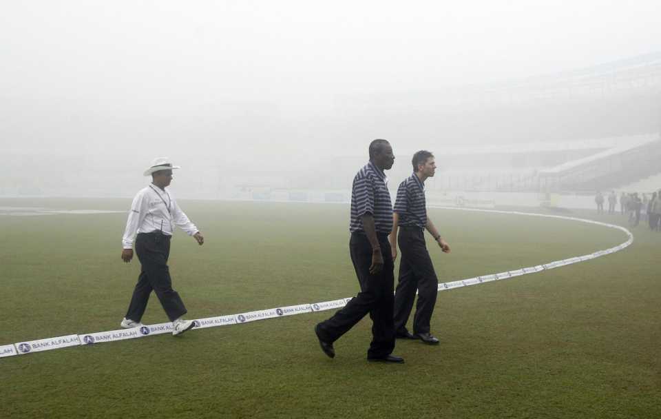 Steve Bucknor, match referee JJ Crowe and reserve umpire Tanvir Ahmed check the fog situation