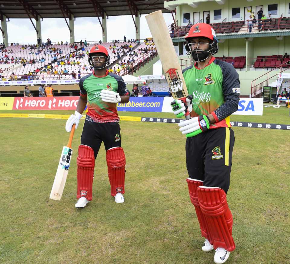 Evin Lewis (left) and Mohammad Hafeez walk out to bat
