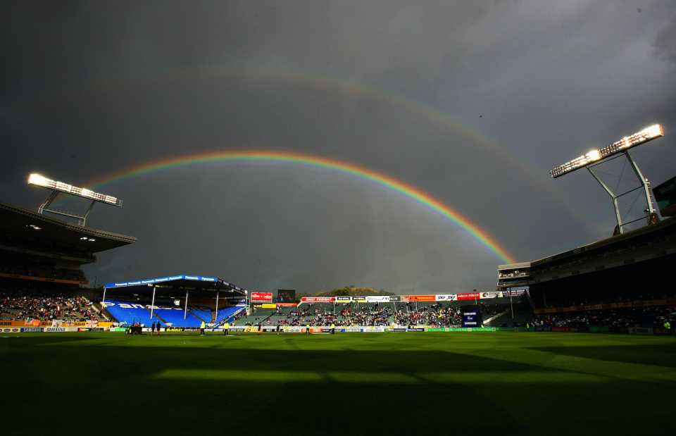 A rainbow appears over the ground as play is stopped due to rain