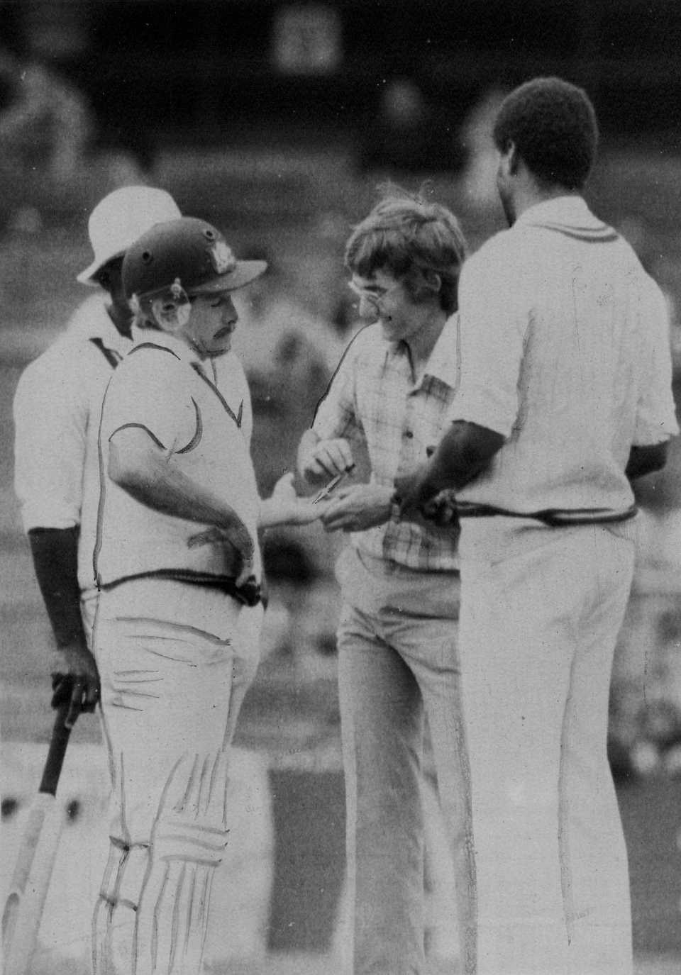 Bruce Laird grimaces while receiving a painkilling injection after being hit on the hand by Michael Holding