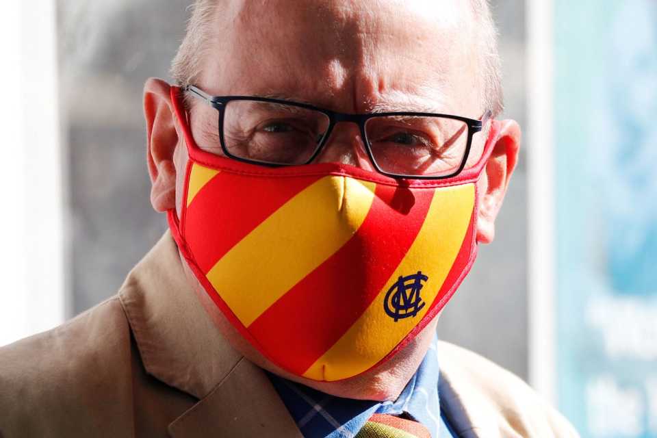 A spectator wears a mask in the MCC colours
