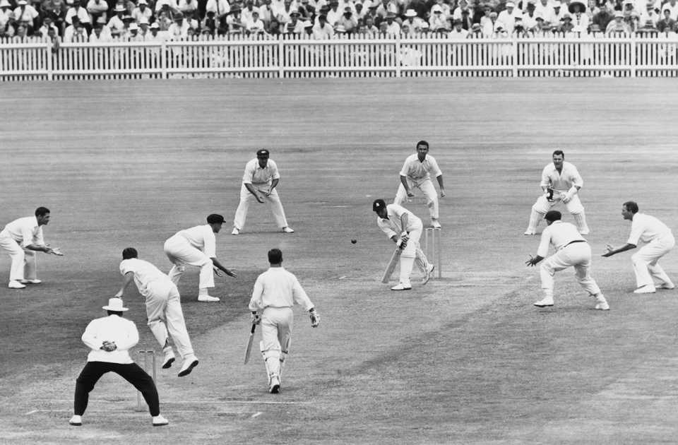 Ted Dexter is surrounded by Australian fielders while playing a shot off Graham McKenzie