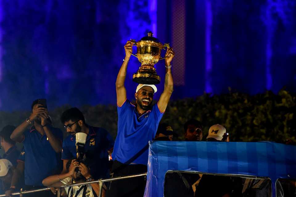 Hardik Pandya lifts the IPL trophy during Mumbai Indians' victory parade on an open-top bus through the city