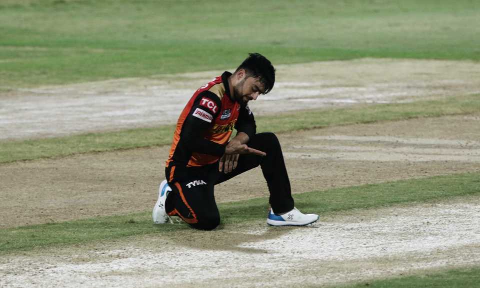 Rashid Khan kneels on the pitch