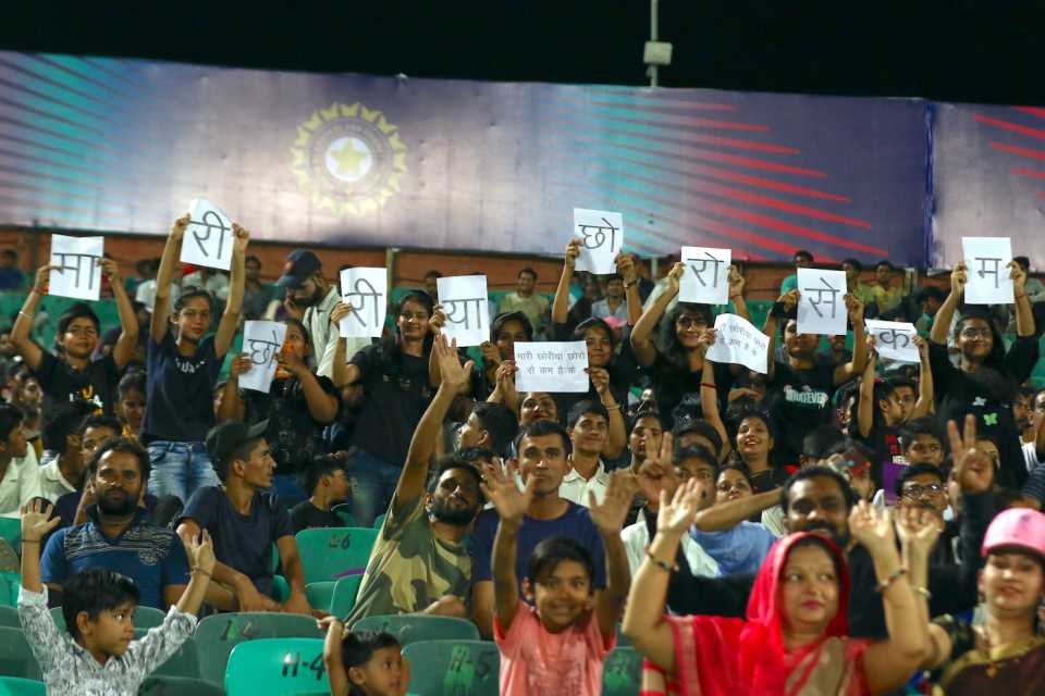 Fans hold up placards saying "Our girl cricketers are no less than our boys"