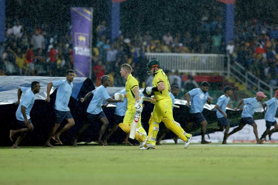 David Warner and Aaron Finch rush off as the covers come in, Sri Lanka vs Australia, 1st T20I, Colombo, June 7, 2022
