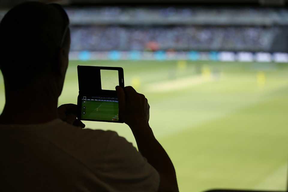 A spectator films the match on his mobile phone