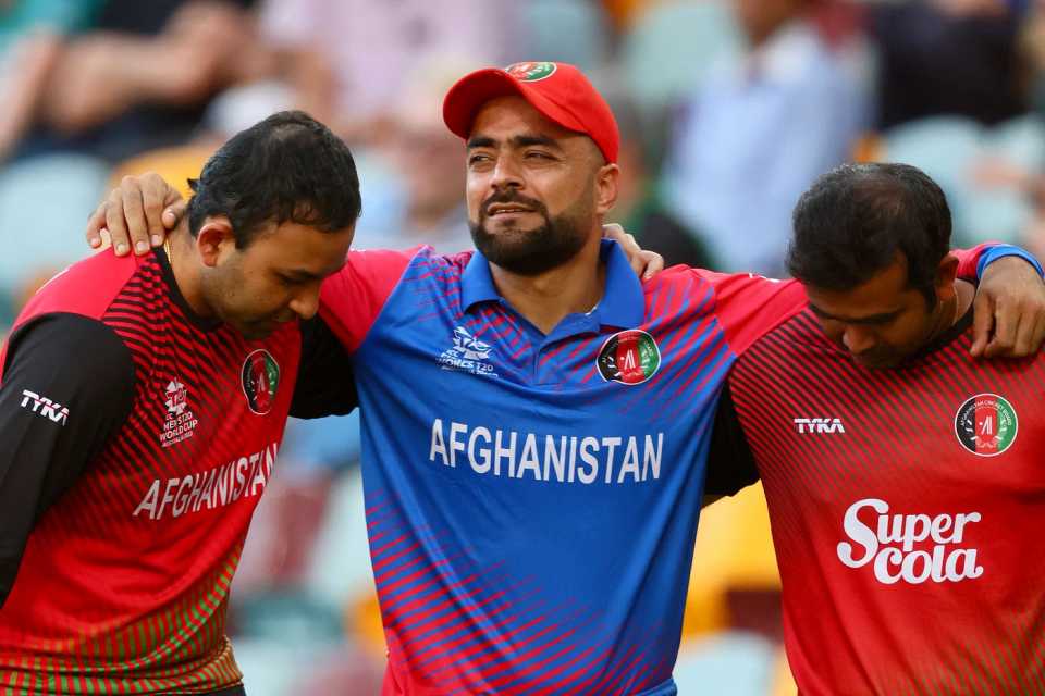 Rashid Khan is helped off the field after jamming his right knee