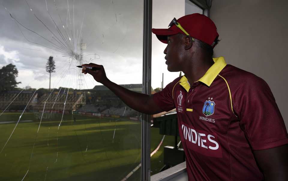 Rovman Powell signs a window he broke at the Harare Sports Club