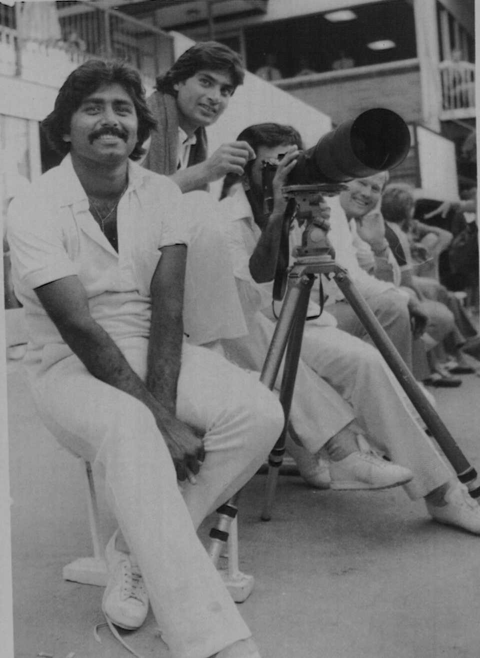 Javed Miandad, Mohsin Khan and Zaheer Abbas look through a photographer's camera during a bad-light delay at the Gabba