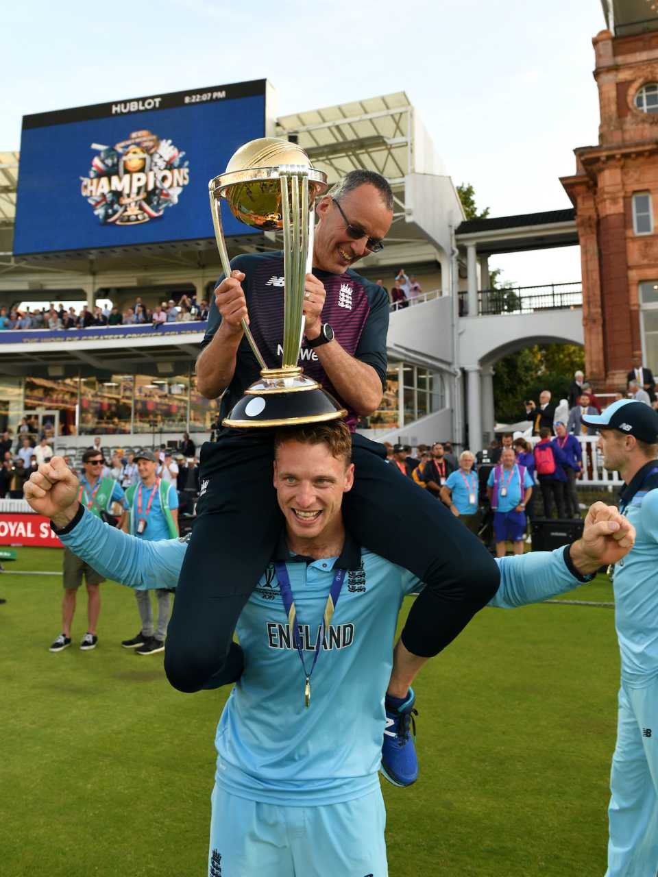 Jos Buttler carries massage therapist Mark Saxby as they celebrate winning the World Cup