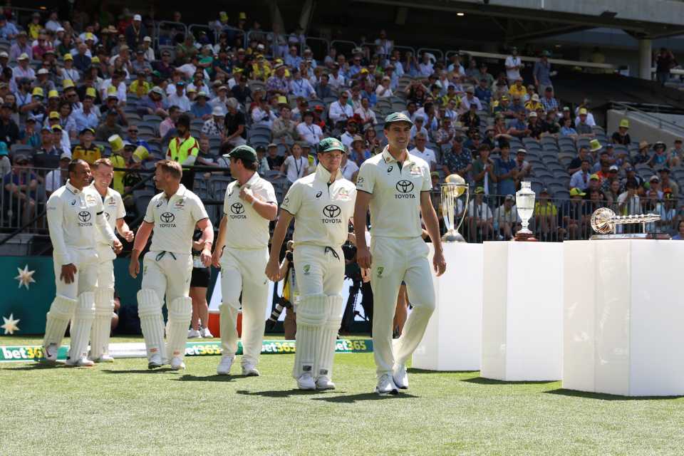 Pat Cummins leads his team past their trophies