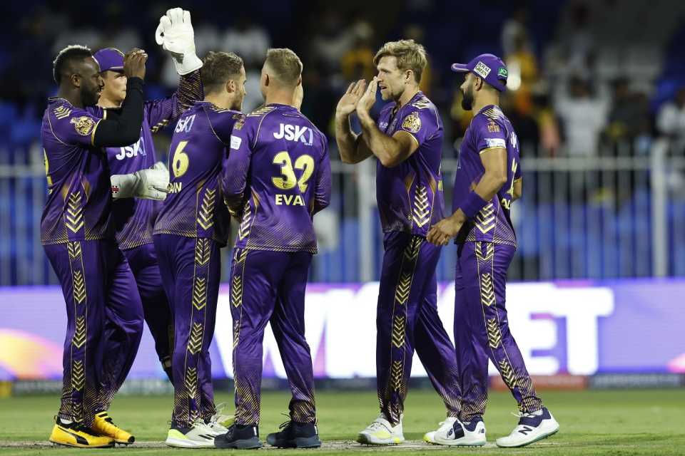 David Willey is mobbed by his team-mates after striking with the new ball, Sharjah Warriors vs Abu Dhabi Knight Riders, ILT20 2024, Sharjah, February 5, 2024