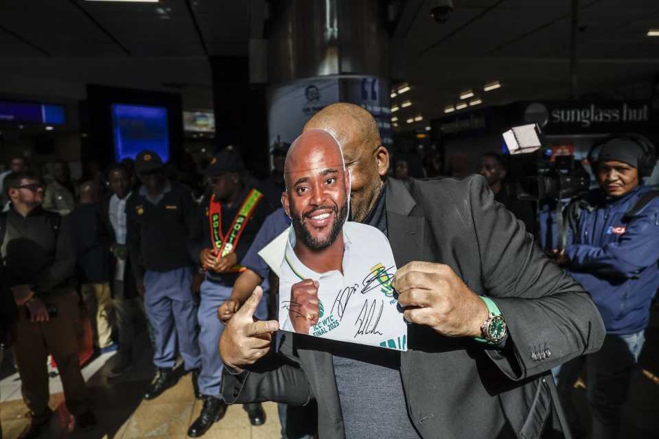 South African minister of sports Gayton McKenzie covers his face with a cut out of Temba Bavuma's face during the Test team's return after winning the World Test Championship, OR Tambo International Airport, Kempton Park, June 18, 2025