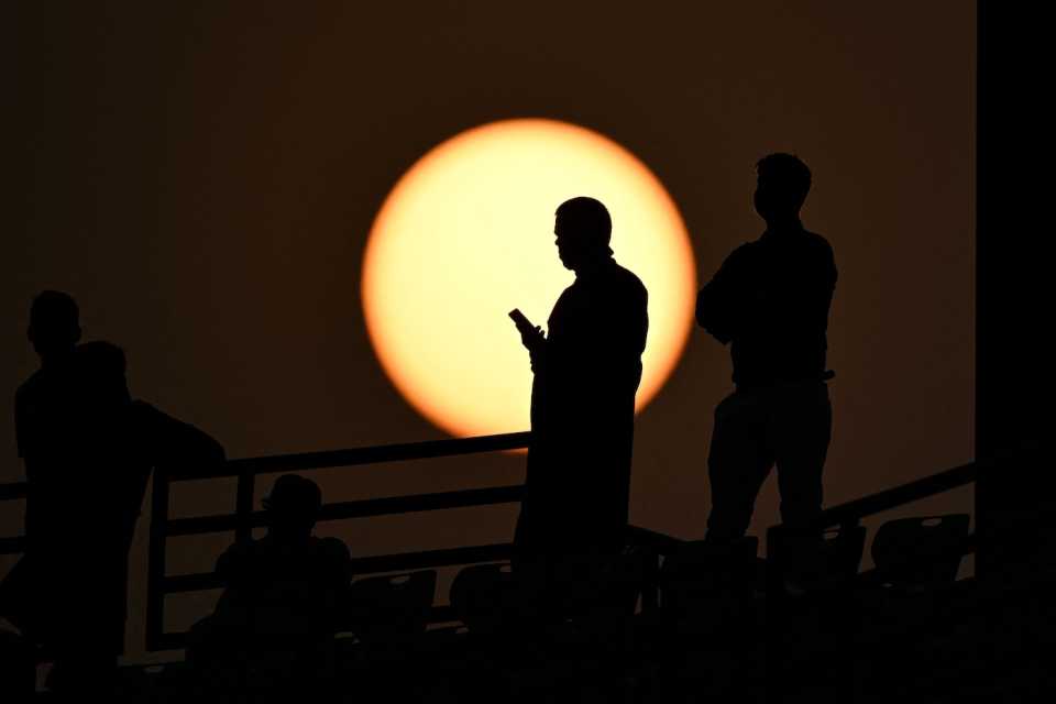 A spectator is silhouetted against the setting sun , Bangladesh vs Sri Lanka, Men's ODI World Cup, November 6, 2023