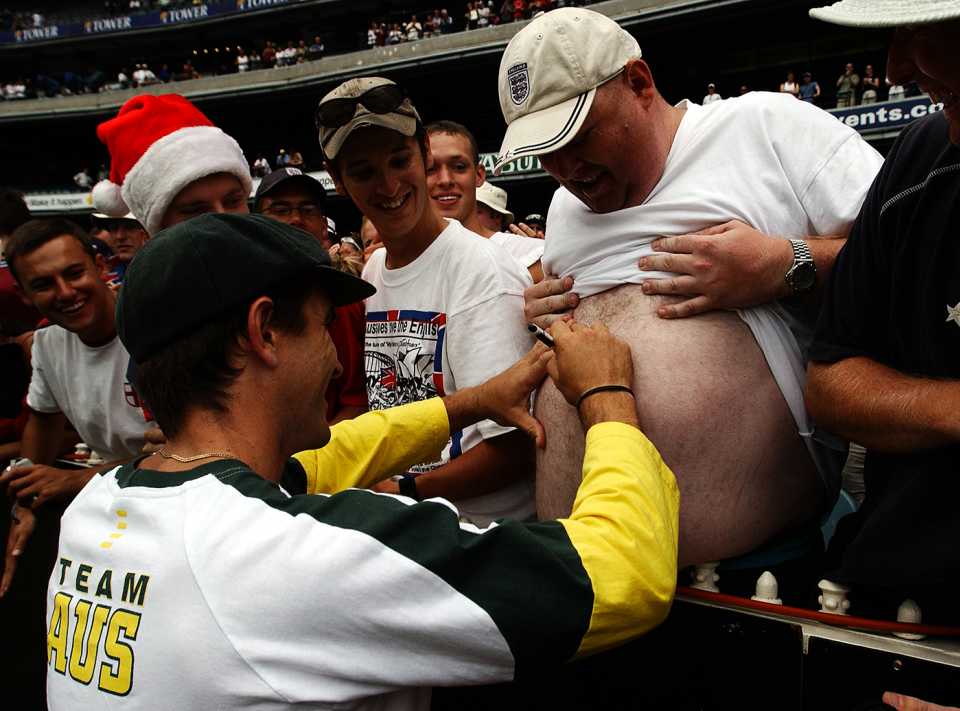 Justin Langer signs a spectator's belly