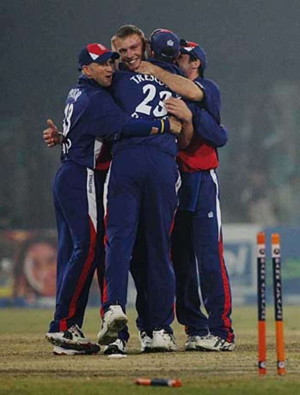 Players mob Flintoff after he takes the final wicket