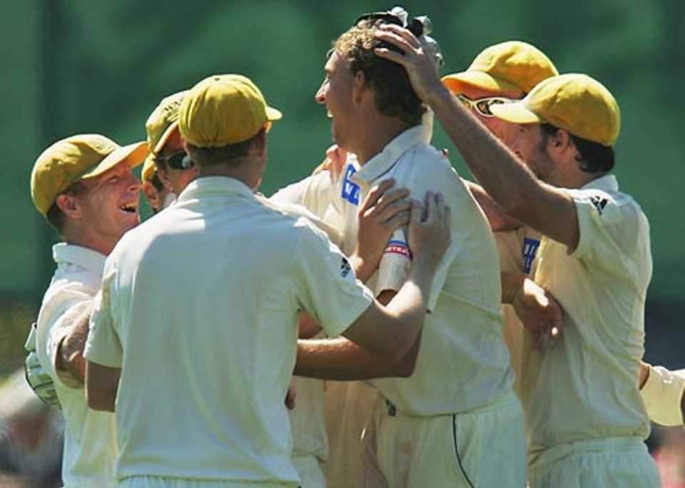 Brett Dorey is mobbed by his team-mates after capturing one of his six wickets