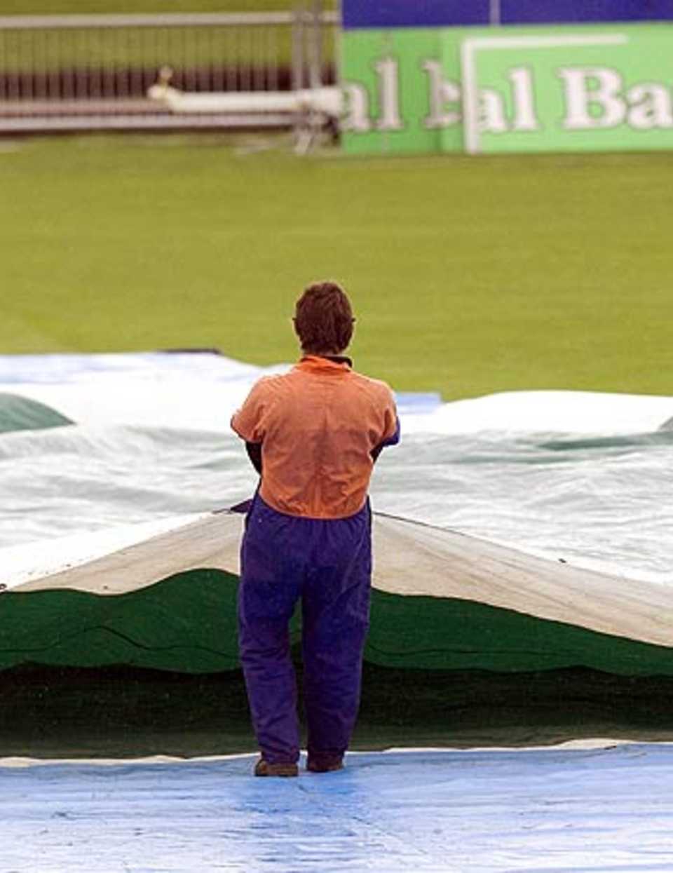 A groundsman brings on the covers at Napier