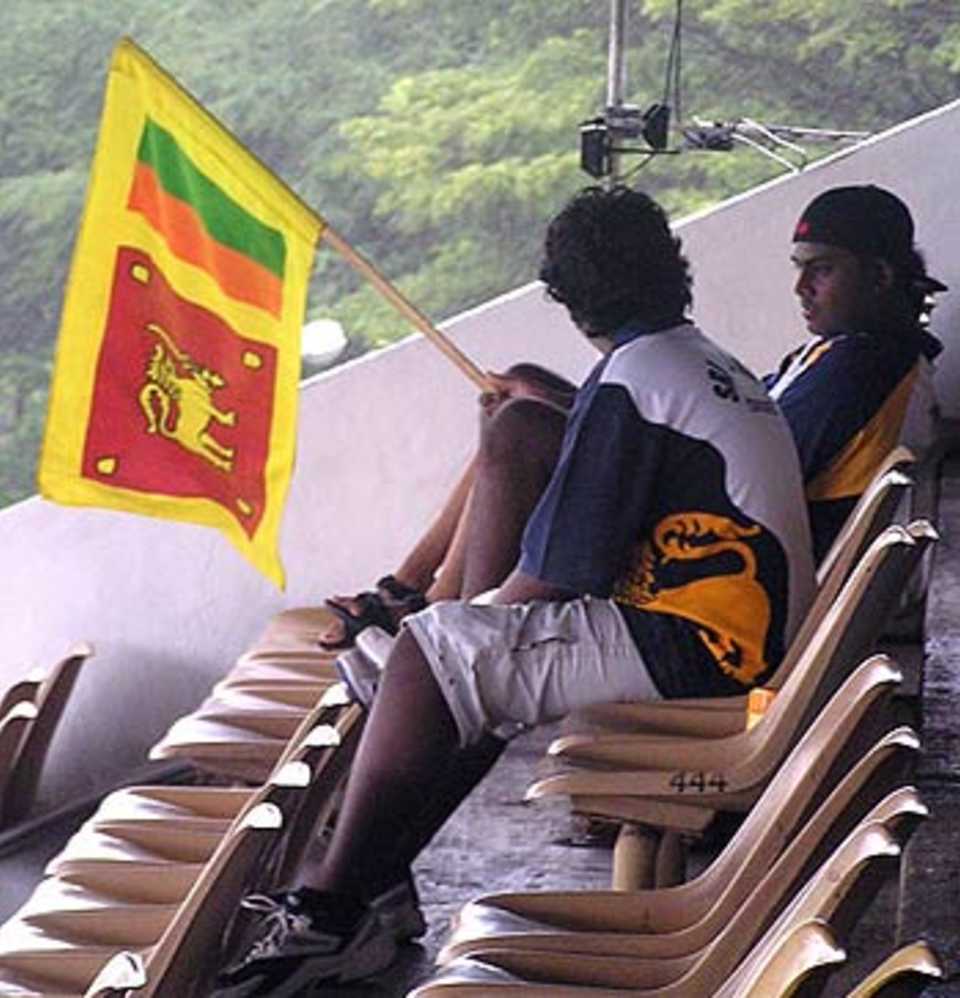 Sri Lankan fans wait for the rain to subside