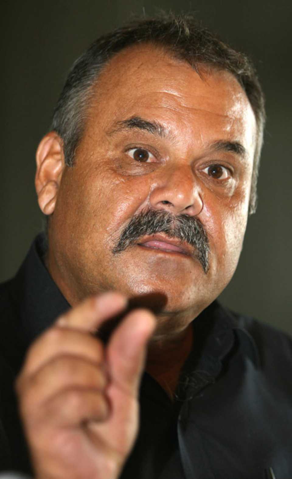 Dev Whatmore gestures during a press conference