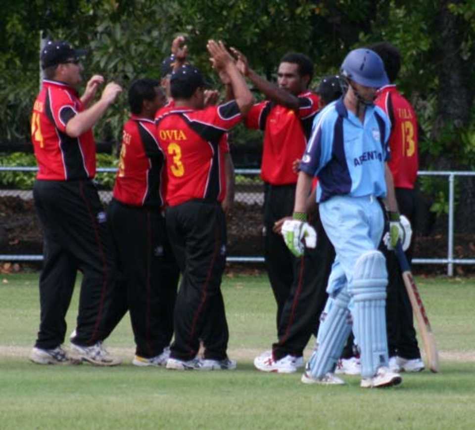 PNG players congratulate Hitolo Areni following the wicket of Matias Paterlini