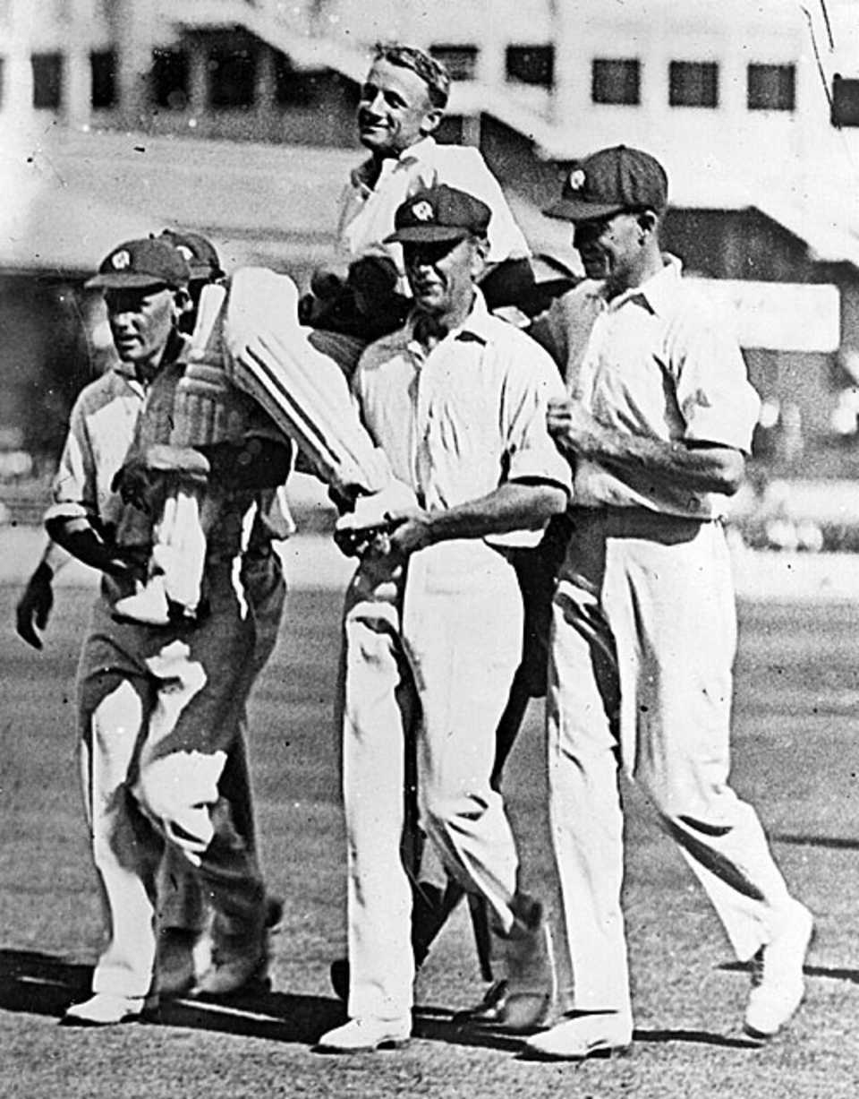 Don Bradman is carried by his team-mates after scoring a record 452