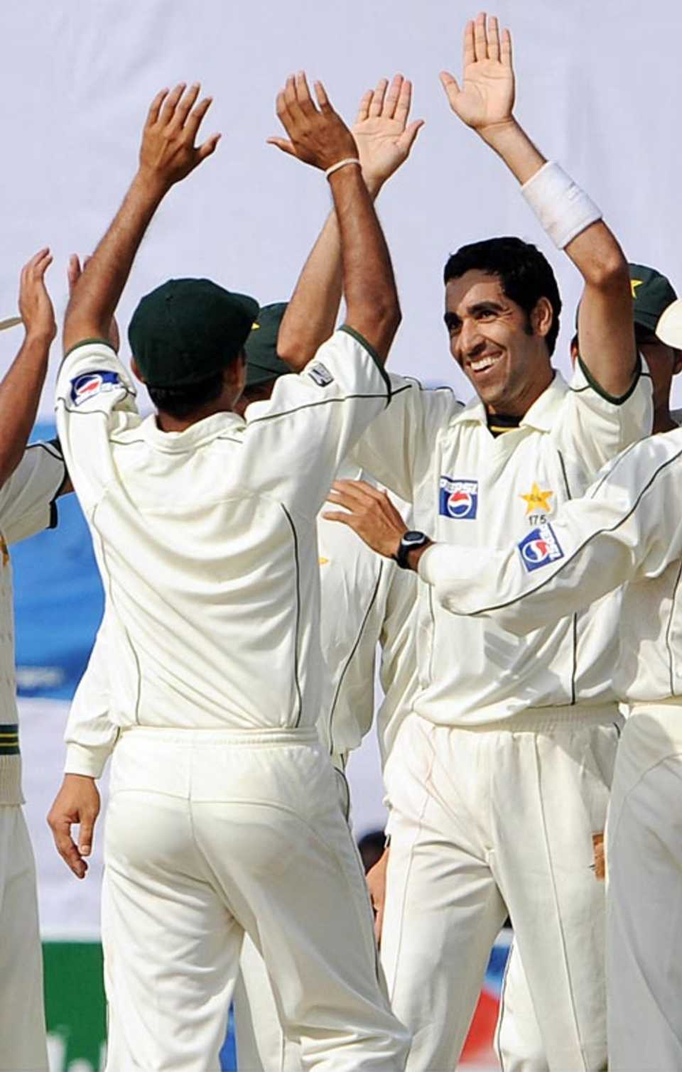 Umar Gul is congratulated by team-mates after picking up his sixth wicket