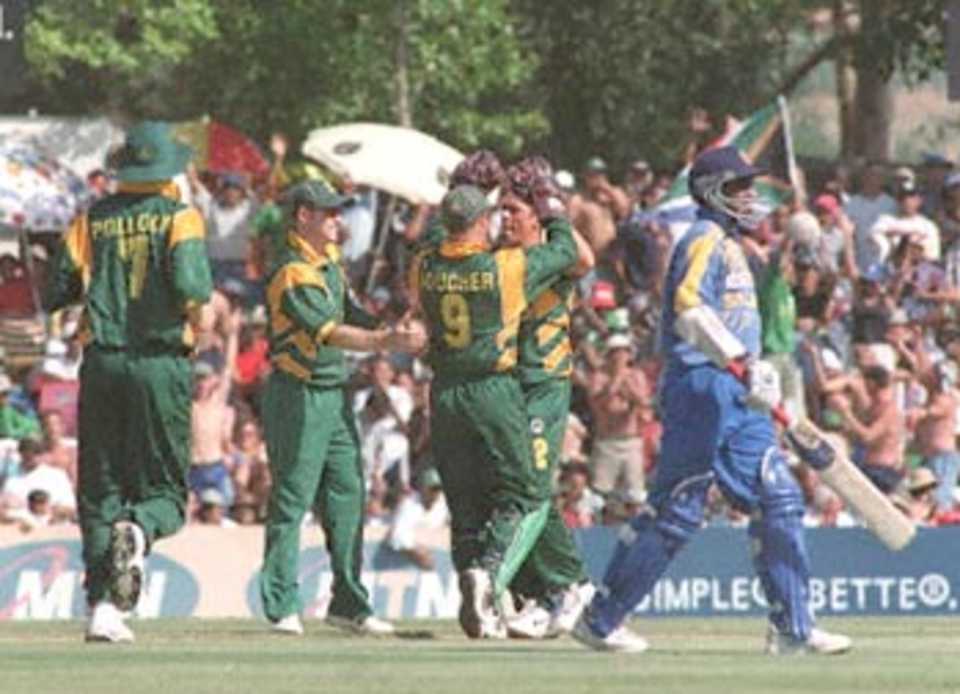 South African bowler Nicky Boje (second from right) is congratulated by his team-mates for taking the wicket of Sri Lankan batsman Sanath Jayasuriya (R) in the third one day international played in Paarl, about 50 kms outside of Cape town 09 January 2000.