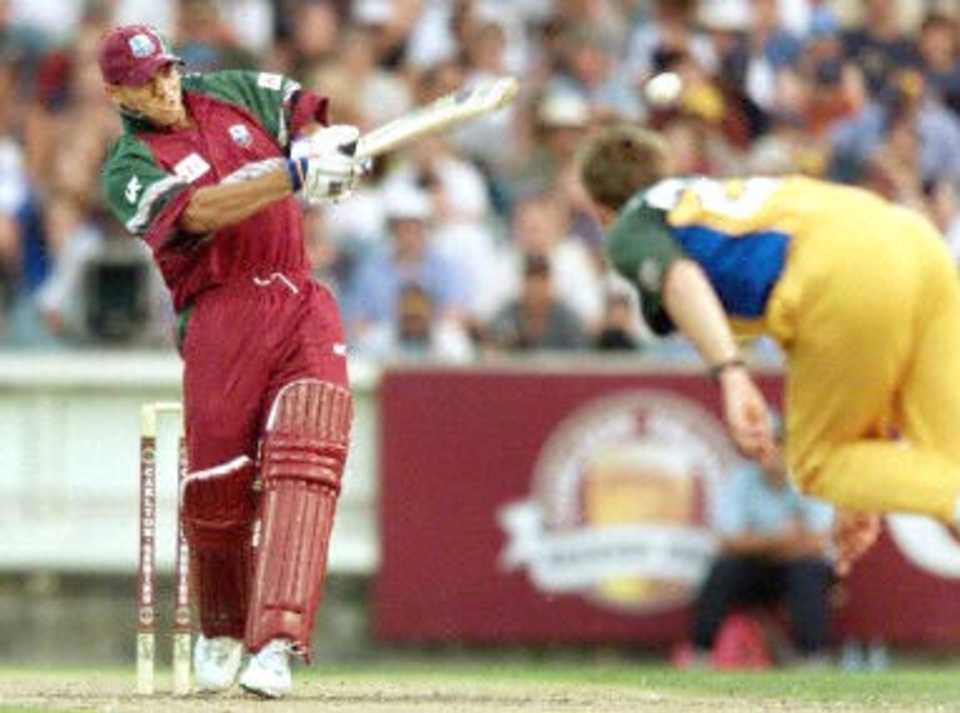 West Indies batsman Ricardo Powell (L) hits out against the Australian bowling of Ian Harvey (R) in their match at the MCG in Melbourne, 11 January 2000. Australia scored 267-6 off their 50 overs and then restricted the West Indies to 193-7 from their 50 overs to go one up in the tri-nations series which also includes Zimbabwe