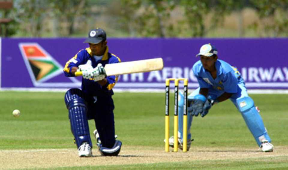 Sri Lanka Under-19 batsman Charith Sylvester shapes to sweep a delivery during his innings of 11 as India Under-19 wicket-keeper Parthiv Patel looks on. ICC Under-19 World Cup Super League Group 1: India Under-19s v Sri Lanka Under-19s at Bert Sutcliffe Oval, Lincoln, 29 January 2002.
