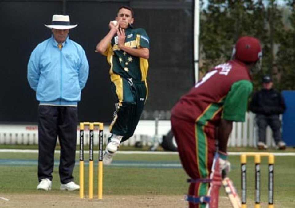 Australia Under-19 bowler Aaron Bird delivers a ball to West Indies Under-19 batsman Tonito Willett during his spell of 1-29 from five overs. Umpire Steve Dunne looks on. 2nd ICC Under-19 World Cup Super League Semi Final: Australia Under-19s v West Indies Under-19s at Bert Sutcliffe Oval, Lincoln, 6-7 February 2002 (7 February 2002).