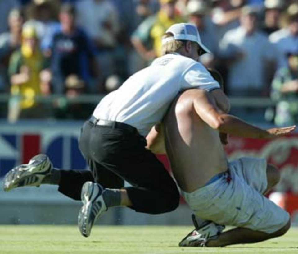 A security guard gets into action as an intruder sneaks into the field, Australia v India, 11th match, VB Series, Perth, February 1, 2004