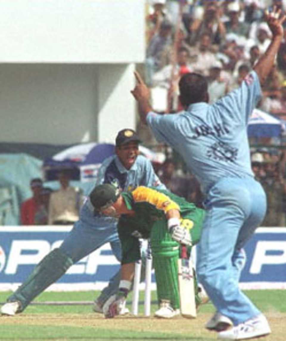 Indian spinner Sunil Joshi (R) raises his hands excitedly as South African batsman Herschelle Gibbs (C) is caught behind by Indian wicket keeper Sameer Dighe (L) on the second one day international cricket match between India and South Africa 12 March 2000, in Jamshedpur in the east Indian state of Bihar. Joshi claimed four vital South African wickets as India went onto win the match by six wickets and take a 2-0 lead in the five match one day series