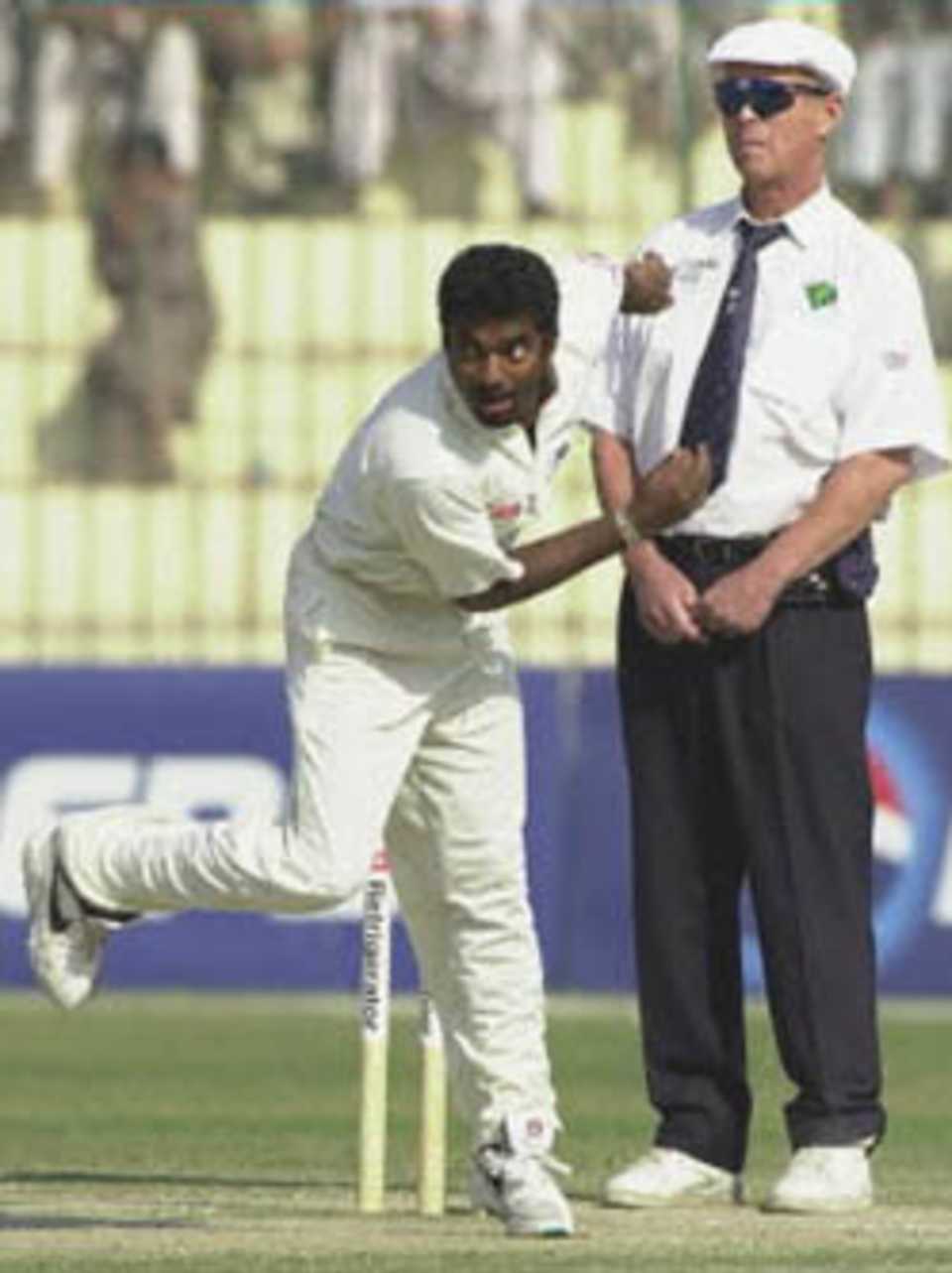 Sri Lankan off-spinner Muttiah Muralitharan delivers his last over on the final day of play of the 2nd cricket Test match in Peshawar, Pakistan 09 March 2000. Muralitharan took 6-71 while collecting ten wickets in the match and was declared Man of the Match. Sri Lanka defeated Pakistan by 57 runs and won the three Test series by 2-0. English umpire John Hampshire is at (R).