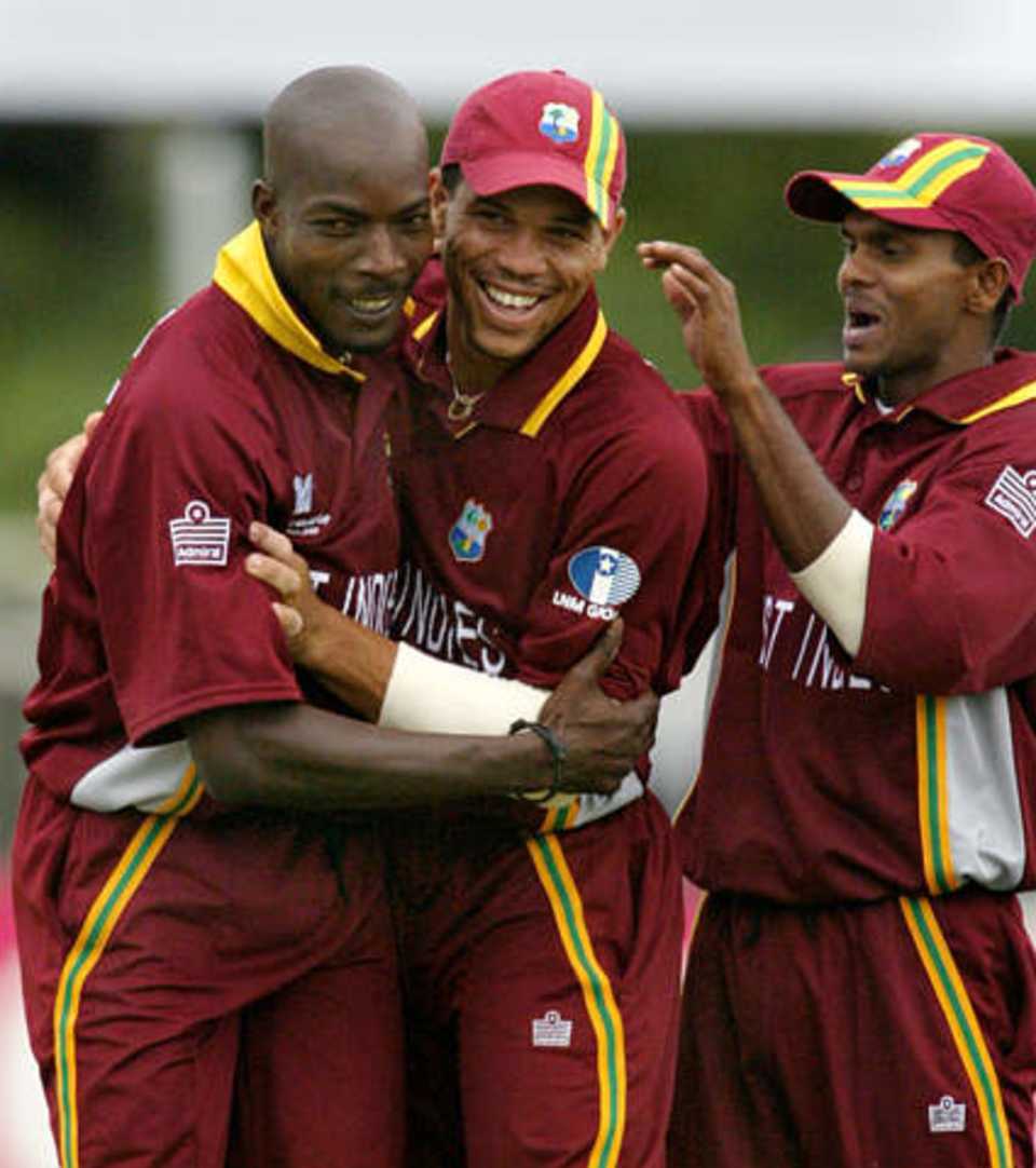 Drakes is congratulated by team-mate Powell and Chanderpaul after getting his fifth wicket
