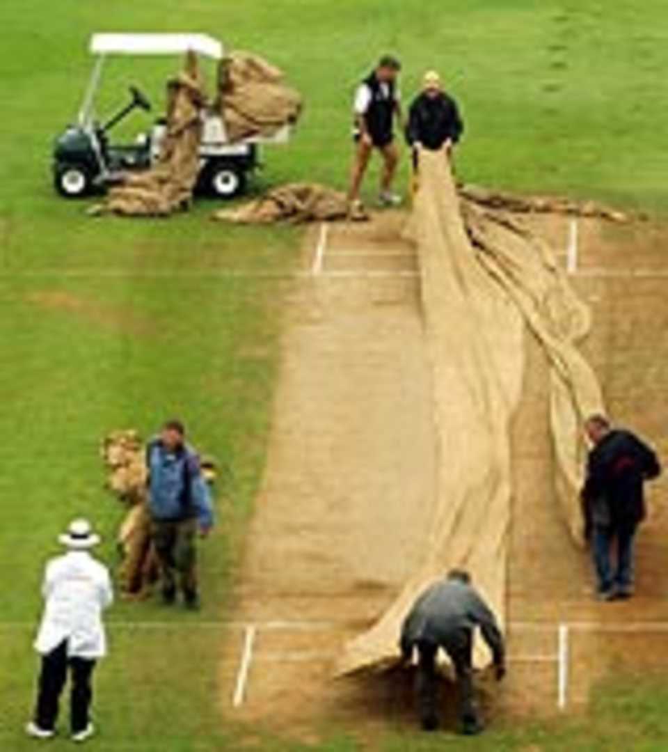 Groundstaff covering the pitch as rain halts play, New Zealand v Australia, 2nd Test, Wellington, 5th day, March 22, 2005