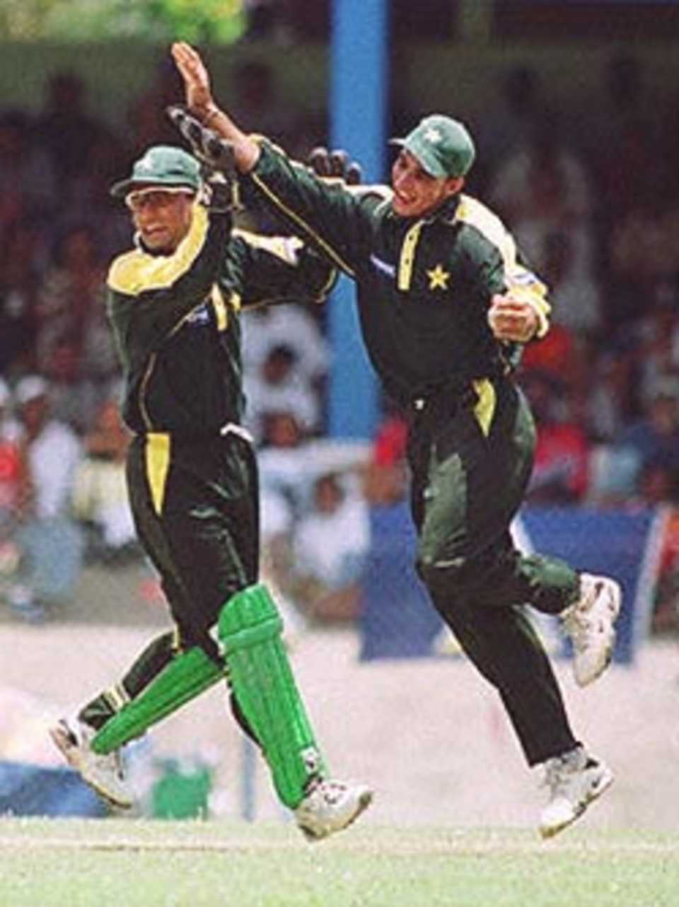 Pakistan's Imran Nazir (R) celebrates with Moin Khan aftercatching West Indie's Batsman Ridley Jacobs  during their match in Port of Spain, Trinidad and Tobago. Third final, Cable and Wireless Series, 23rd April 2000.