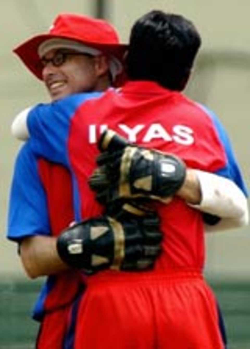 Two Hong Kong players celebrate a wicket
