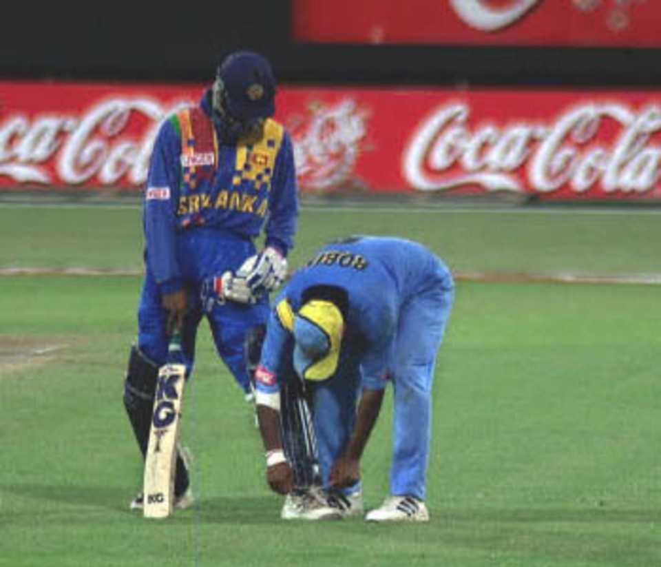Robin Singh does Russel Arnold a favour - helping the lad with his laces, Coca-Cola Champions Trophy, 2000/01, 6th Match, India v Sri Lanka, Sharjah C.A. Stadium, 27 October 2000.