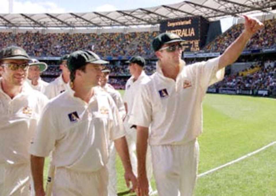 Australia fast bowler Glenn McGrath (R), who finished with the match figures of 10-27, walks off the field with captain Steve Waugh (C) and Michael Slater (L) after defeating the West Indies by an inning and 126 runs, on the third day of the first Test match at the Gabba in Brisbane, 25 November 2000. The Australian victory equals the world record of eleven consecutive Test victories.