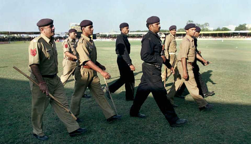 Policemen step onto the ground after the trouble at Rajkot
