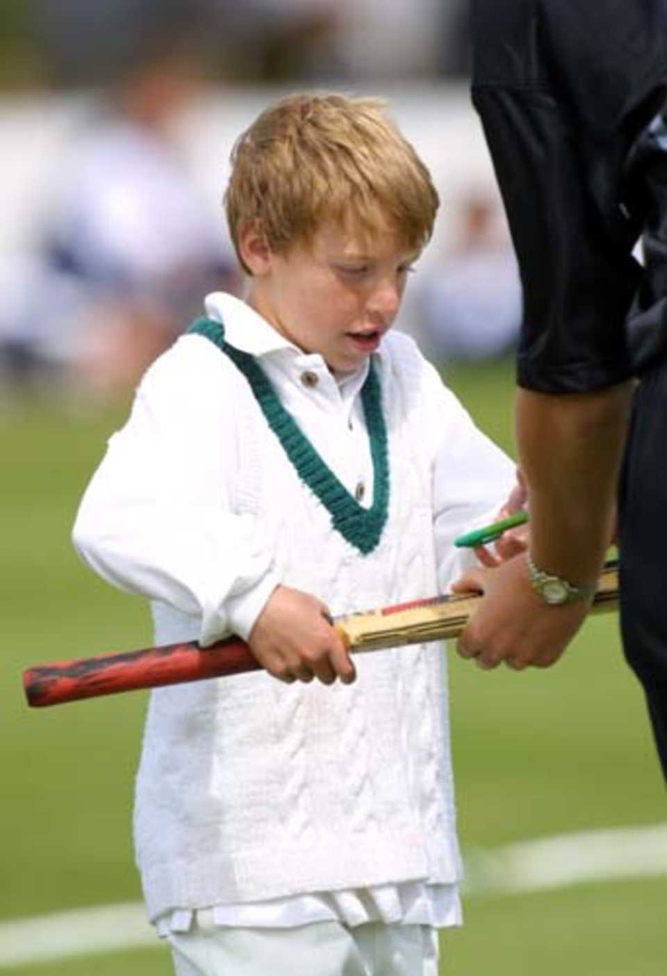 A young fan gets an autograph on his bat from White Fern