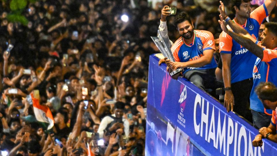 Rohit Sharma, trophy in hand, soaks in the atmosphere of the open-top bus parade, Mumbai, July 4, 2024